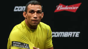 MMA 拳手在帶有 Budweiser 和 Combate 標誌的新聞活動中穿著黃色 Reebok 襯衫。 — 運動風 壁紙