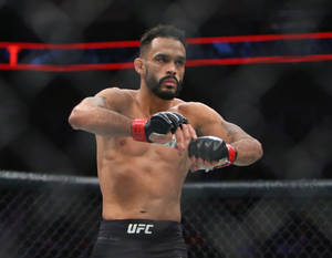 MMA選手在UFC八角籠中以專注的表情準備戰鬥。 — 運動 壁紙