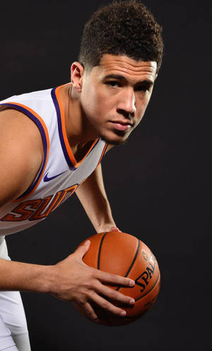 太陽隊球衣籃球運動員在工作室手持籃球 — Devin Booker 壁紙