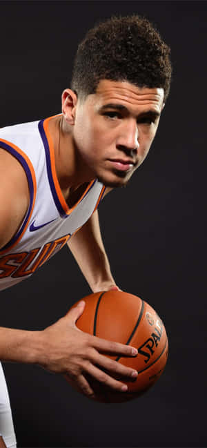 太陽隊球衣籃球運動員在工作室拿著球 — Devin Booker 壁紙