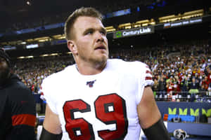 夜間比賽中，足球員69號在場上，背景有觀眾。 — NFL 美式足球 壁紙