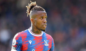 比賽中，梳著辮子頭的足球運動員穿著紅藍球衣。 — 運動 壁紙