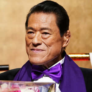 一位優雅的老年男士身穿燕尾服，搭配紫色領結和圍巾，在活動中微笑。 — 運動 壁紙