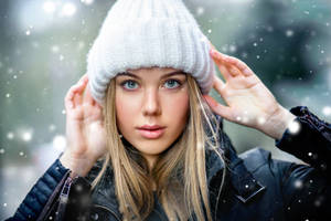 年輕女性穿著冬季外套和白色毛帽，站在飄雪中。 — 可愛的雪 壁紙