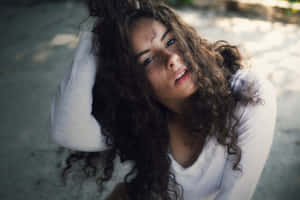 年輕女性，捲髮，在戶外若有所思地抬頭仰望。 — 貝蒂·懷特 壁紙