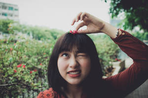 年輕女性眨眼並在戶外用手指做出心形。 — 花朵 壁紙