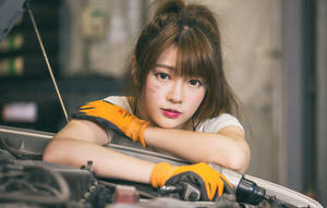 年輕女機械師戴橙色手套將手臂擱在汽車引擎蓋上 — 模特兒 壁紙