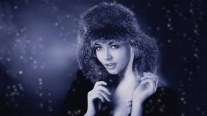 戴皮帽的女性站在飄雪的冬日場景中。 — 模特兒 壁紙