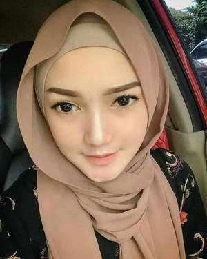 一位戴米色頭巾的女性在車內微笑。 — 可愛女孩 壁紙