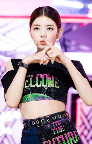 K-pop表演者穿著未來風格服裝，在舞台上做出手指放在唇邊的手勢。 — Redmi Pad 壁紙