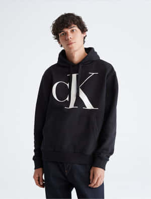 年輕男子身穿黑色Calvin Klein連帽衫和牛仔褲在攝影棚擺姿勢 — 卡文克萊 壁紙