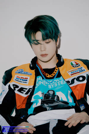 年輕男子留著藍綠色頭髮，穿著賽車夾克在室內擺姿勢。 — Nct 127 壁紙