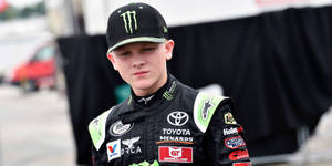 年輕賽車手穿著 Toyota Menards 賽車裝備向前看。 — Monster Energy 壁紙