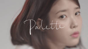 一位年輕黑髮女子的特寫肖像，表情柔和，上面覆蓋著「Palette」字樣。 — 女演員 壁紙