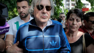 穿著藍色Adidas夾克和太陽眼鏡的男性被記者和人們包圍。 — 運動 壁紙