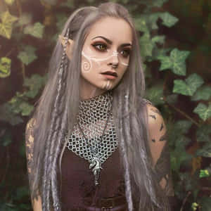 一位幻想精靈女性，銀色頭髮和紋身，站在綠色常春藤中。 — 仙女美學 壁紙