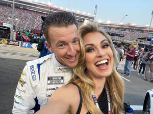 NASCAR車手和女子在賽車場活動中微笑 — 情侶 壁紙