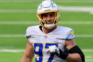 NFL足球運動員穿著Chargers制服在草地上奔跑。 — 運動 壁紙