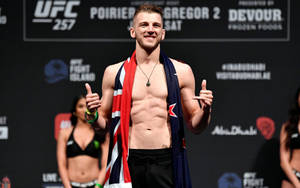 UFC拳手在稱重活動中微笑並披著英國國旗。 — 運動 壁紙