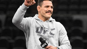 UFC拳手微笑並舉起拳頭，同時手持麥克風。 — 極限運動 壁紙