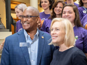 參議員 Emanuel Jones 在室內政治活動中與一位女性微笑。 — 人物 壁紙