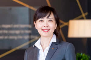 專業女性穿著商務服裝在現代辦公室環境中微笑。 — 終極格鬥冠軍賽 壁紙
