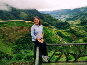 女子對著鏡頭微笑，背景是梯田和山巒。 — 菲律賓 壁紙