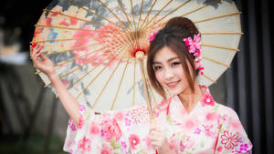 身穿粉紅花卉和服的女子手持花卉陽傘 — 模特兒 壁紙