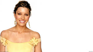 Jessica Bell 微笑著，身穿帶蝴蝶結肩部細節的黃色露肩連衣裙。 — 模特兒 壁紙