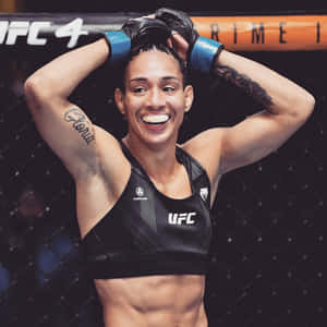 女性MMA拳手在八角籠內微笑舉起雙臂。 — 運動 壁紙