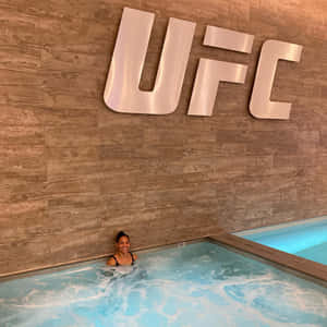女性在木牆上UFC標誌下的熱水浴缸中微笑 — 終極格鬥冠軍賽 壁紙