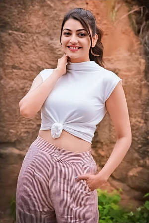 身穿白色上衣和條紋褲的女性在戶外懸崖附近微笑 — 女演員 壁紙