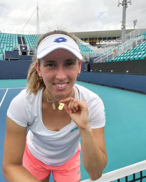 女網球選手在球場上微笑並高舉金牌。 — 運動 壁紙