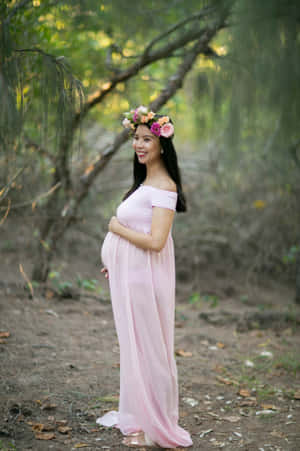 孕婦穿著粉紅色連衣裙和花冠站在森林中 — 婚紗 壁紙