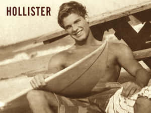 年輕男子在海灘木製碼頭上手持衝浪板 — Hollister 壁紙