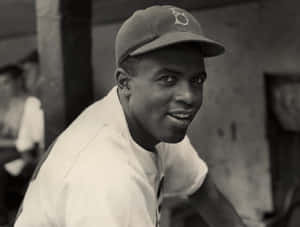 穿著制服和帽子的微笑棒球運動員的黑白肖像。