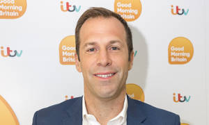 身穿藍色西裝的男士在Good Morning Britain背景前微笑看著鏡頭。 — 運動 壁紙