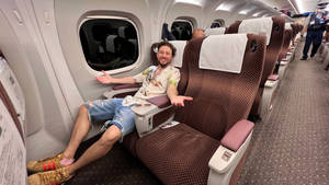 男子在飛機座位上微笑伸展 — 火車 壁紙