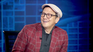 穿著紅色格紋外套和帽子的男子在訪問中微笑。 — 最佳 壁紙