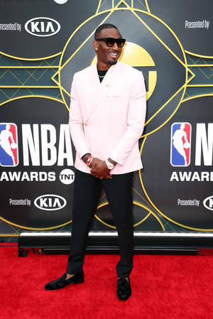 身穿粉紅色西裝外套的男子在NBA頒獎典禮紅地毯上微笑。 — 美學科比 壁紙