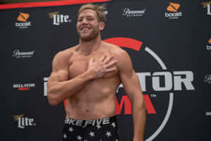 赤裸上身的MMA戰士在稱重活動中微笑著將手放在胸前。 — 運動 壁紙