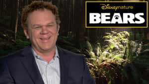 西裝男子在森林前微笑，帶有DisneyNature Bears標誌。 — 克里斯·普瑞特 壁紙