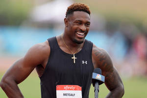 運動員在賽道採訪中微笑，旁邊有麥克風 — Dk Metcalf 壁紙