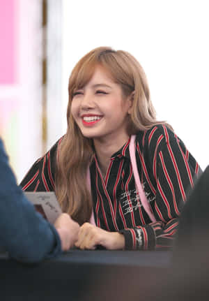 女性在活動中帶著燦爛笑容簽名。 — Lalisa manoban 動圖 壁紙