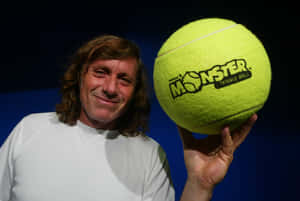 男子拿著標有Monster Tennis Ball的巨型黃色網球 — 運動 壁紙