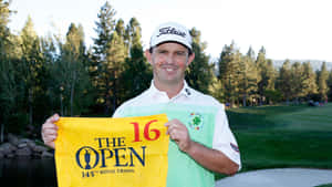 高爾夫球手在陽光明媚的高爾夫球場第16洞舉起The Open 145th Royal Troon旗幟。 — 運動 壁紙