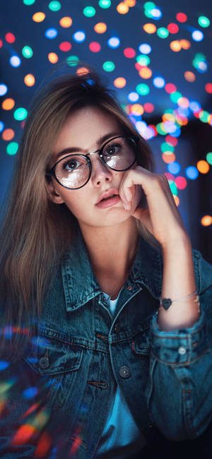 戴眼鏡和牛仔外套的年輕女子，背景是色彩繽紛的夜燈。 — 酷女孩 壁紙