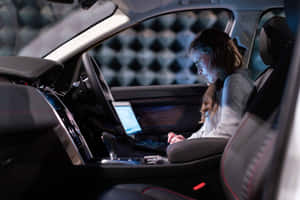 女性在現代汽車內使用筆記型電腦工作（夜間） — 酷車 壁紙