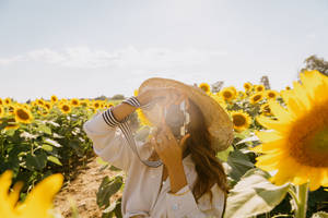 戴草帽的女士在向日葵田用相機拍照 — 相機 GIF 壁紙