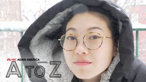 年輕女子穿著冬季外套和眼鏡站在雪中 — 寒冷 壁紙